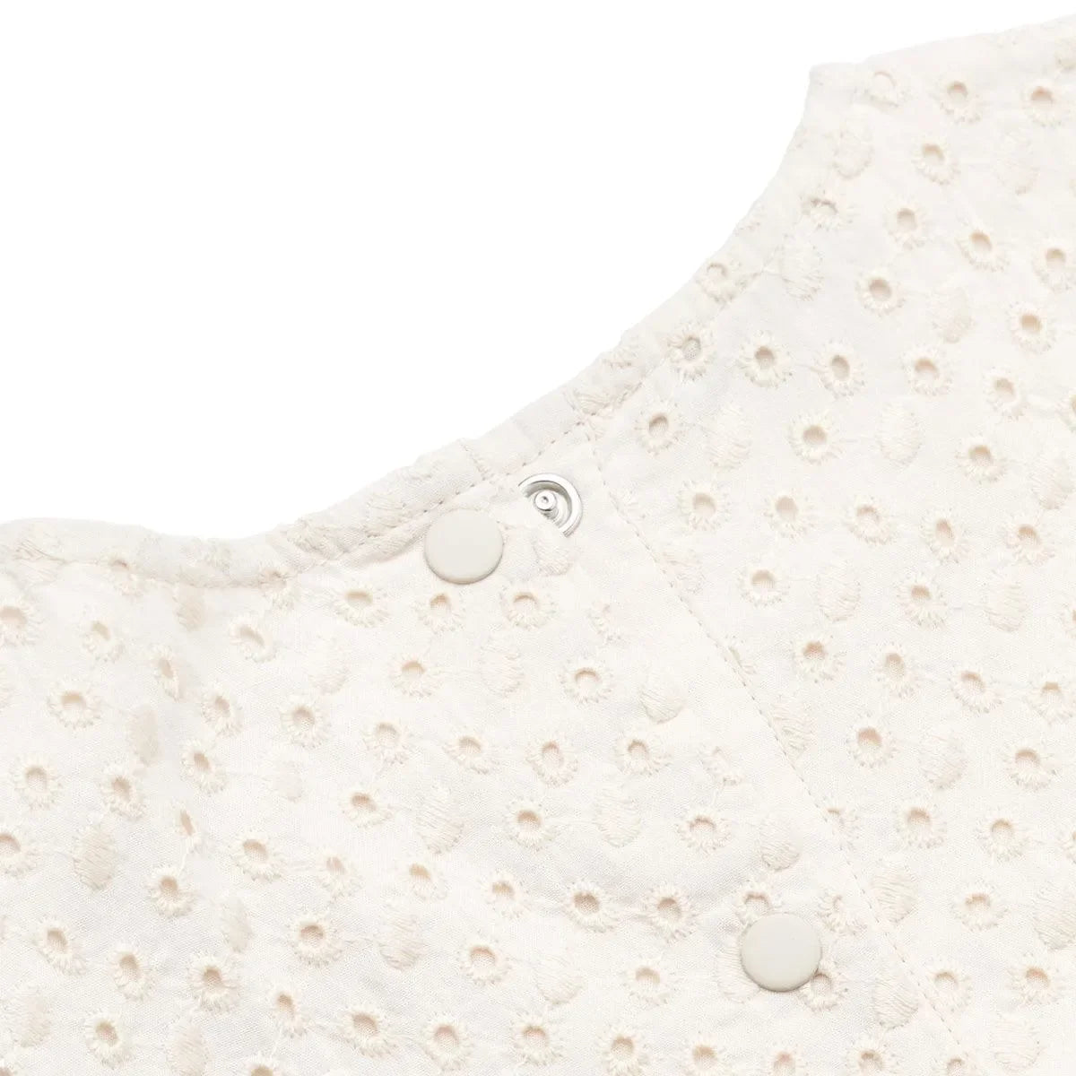 Detailaufnahme Babyoberteil aus Broderie Anglaise in Beige mit Druckknöpfen am Rücken