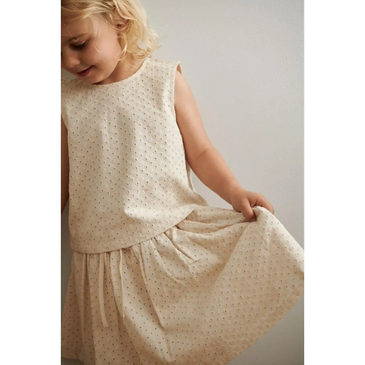 Mädchen in besticktem, ärmellosem Sommertop und Rock aus Bio-Baumwolle in Beige