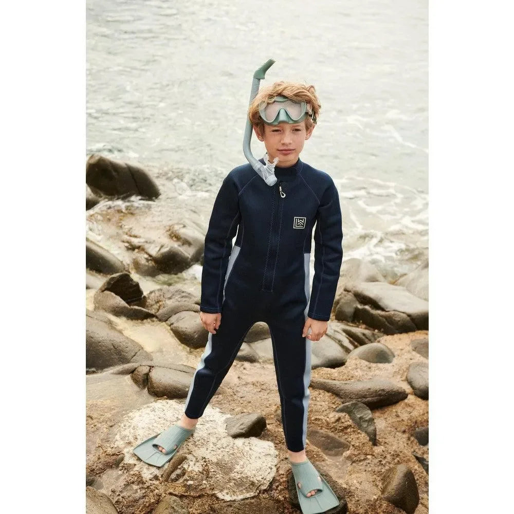 Junge im Neoprenanzug mit Schnorchel und Flossen am Strand, Kinder Badebekleidung