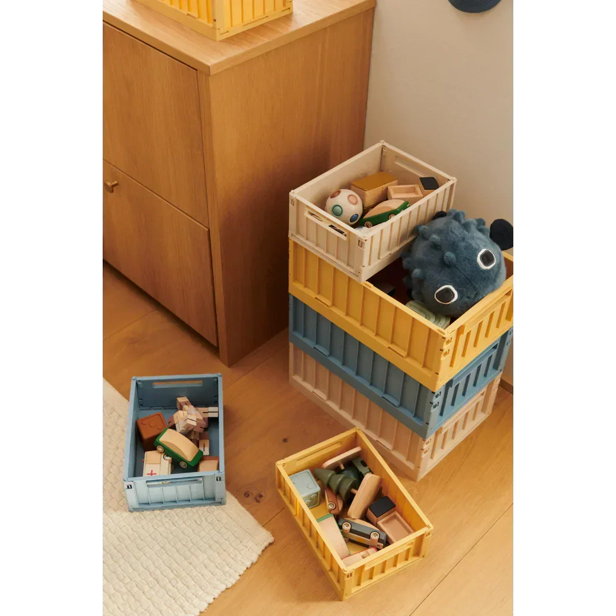 Bunte Aufbewahrungsboxen mit Holzspielzeug und Kuschelfigur im Kinderzimmer, Nook' d' Mel