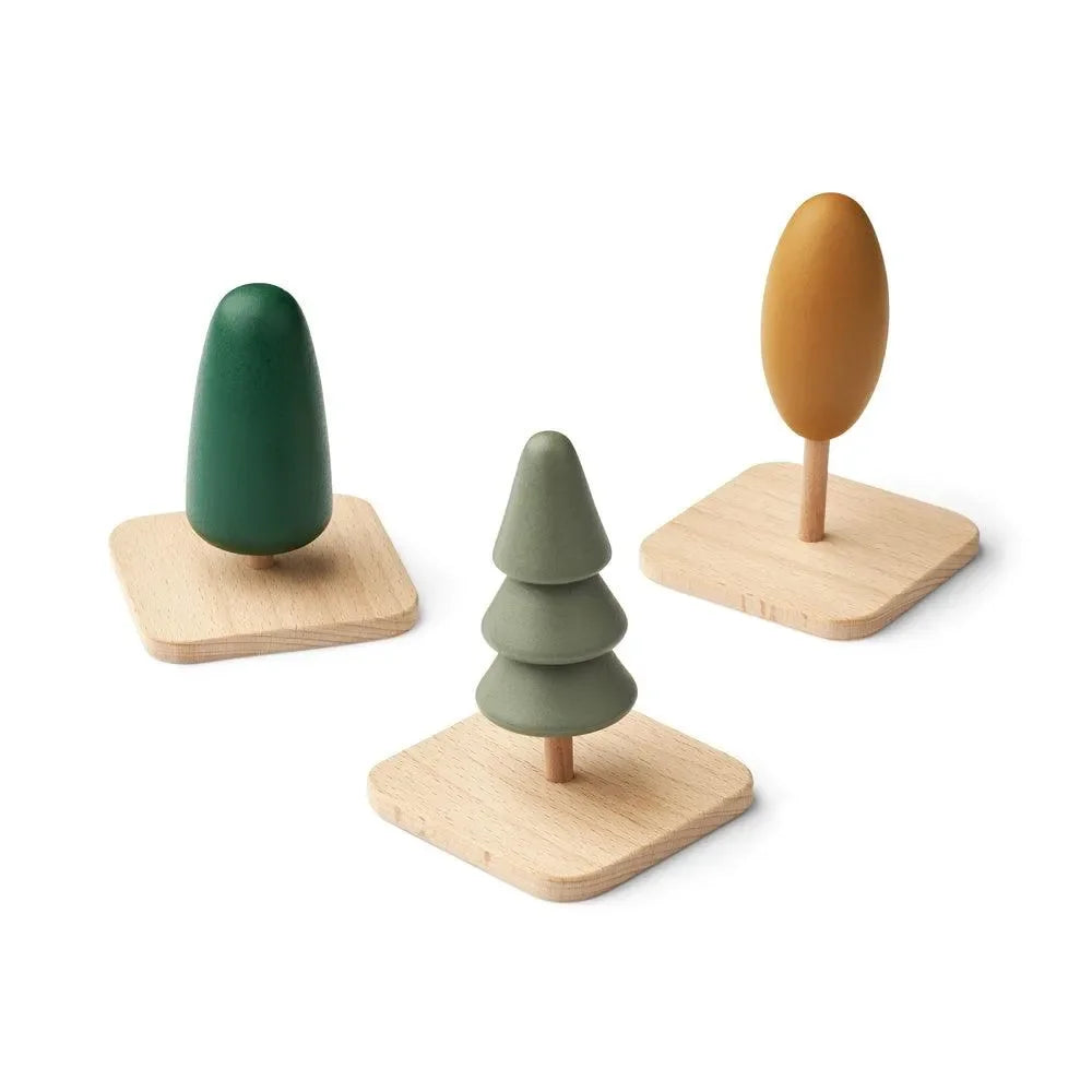 Drei minimalistische Holzspielzeug-Bäume auf Holzplatten in grünen und gelben Farbtönen