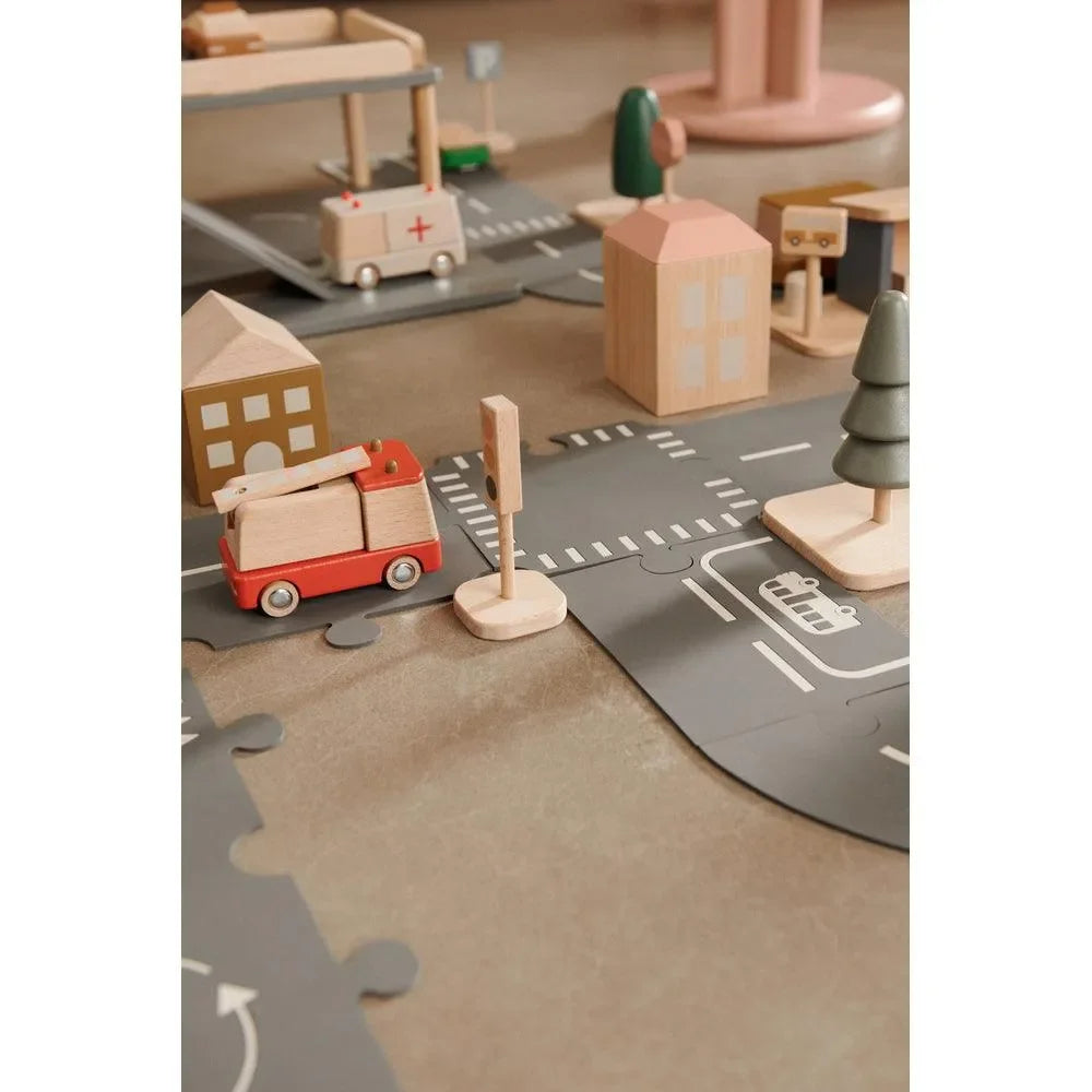 Holzspielzeug-Stadt mit Feuerwehrfahrzeug, Häusern, Ampel und Straßenmatte