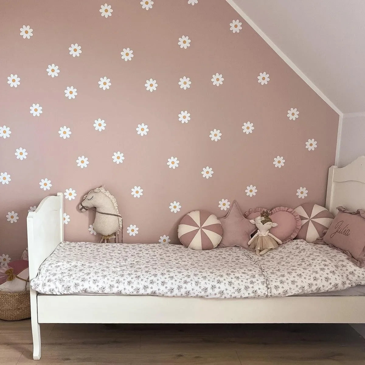Kinderzimmer mit weißem Bett, rosa Wand und Gänseblümchen Wandtattoos, Deko Kissen