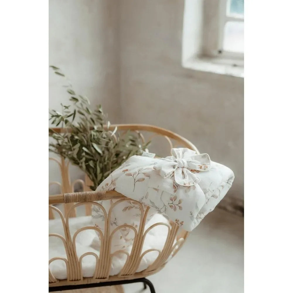 Bambus Wickeldecke mit floralem Muster auf Babybett, Boho Kinderzimmer Deko
