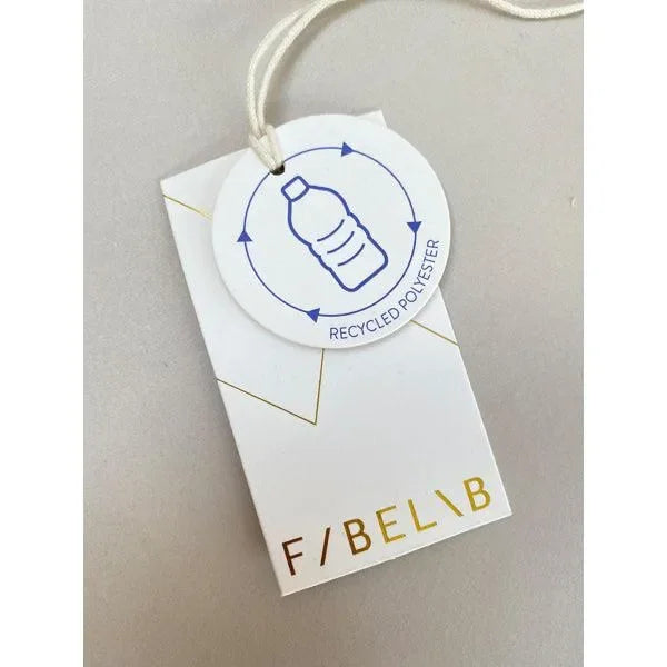 Anhänger mit recyceltem Polyester Symbol und weiß-goldenem Etikett auf hellem Hintergrund