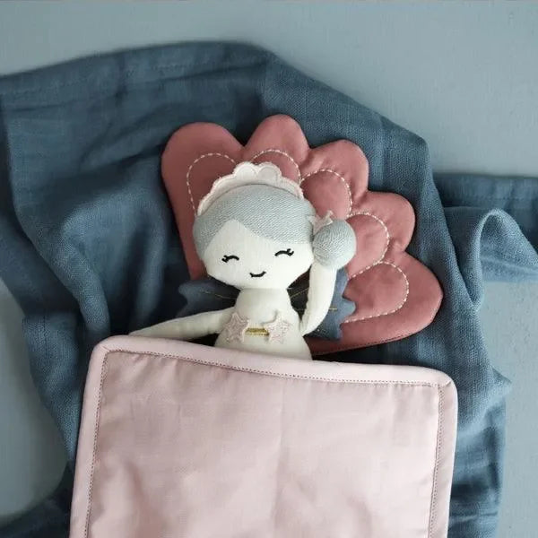 Stoffpuppe Meerjungfrau mit grauen Haaren und rosa Kissen, liegt unter rosa Decke