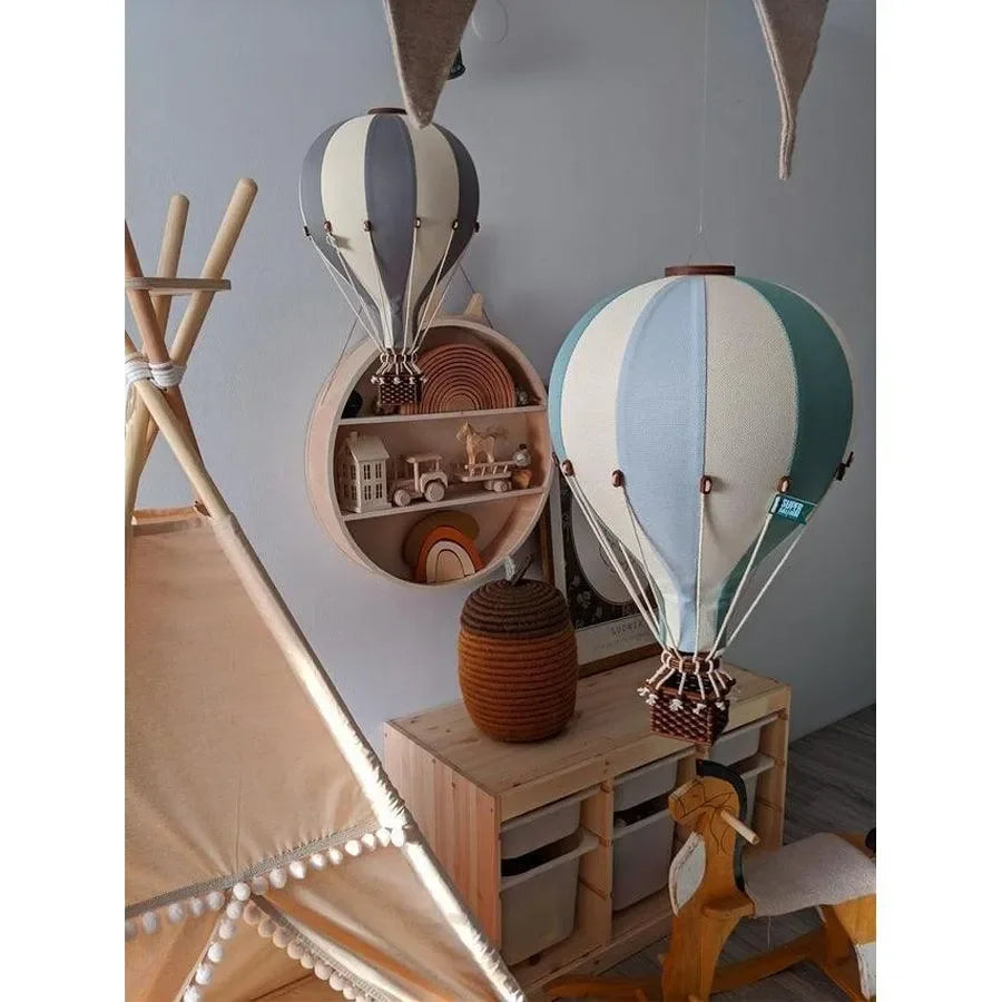 Heißluftballon Kinderzimmer Deko in Pastellfarben über Holzregal und Spielzeug