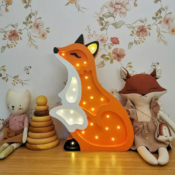 Fuchs Kinderzimmerlampe LED in Rot, leuchtend, neben Stofftieren und Holzspielzeug