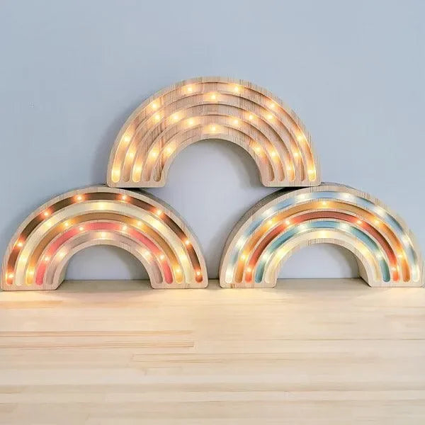 Drei LED Regenbogen Kinderlampen aus Holz als Kinderzimmer Deko auf hellem Boden