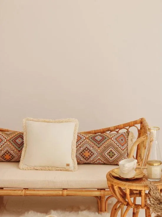 Weißes Samtkissen mit Fransen auf Rattansofa, Boho Deko im Kinderzimmer