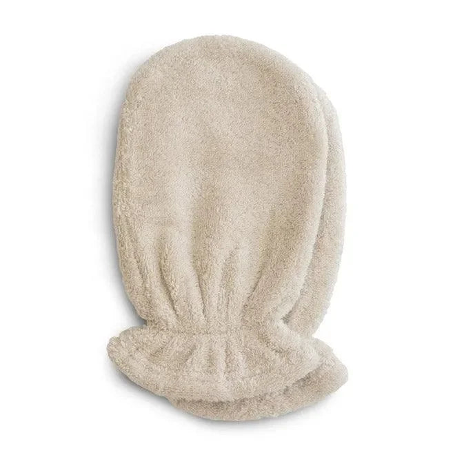 Zwei beige Baby Badehandschuhe aus weichem Frottierstoff, übereinandergelegt.