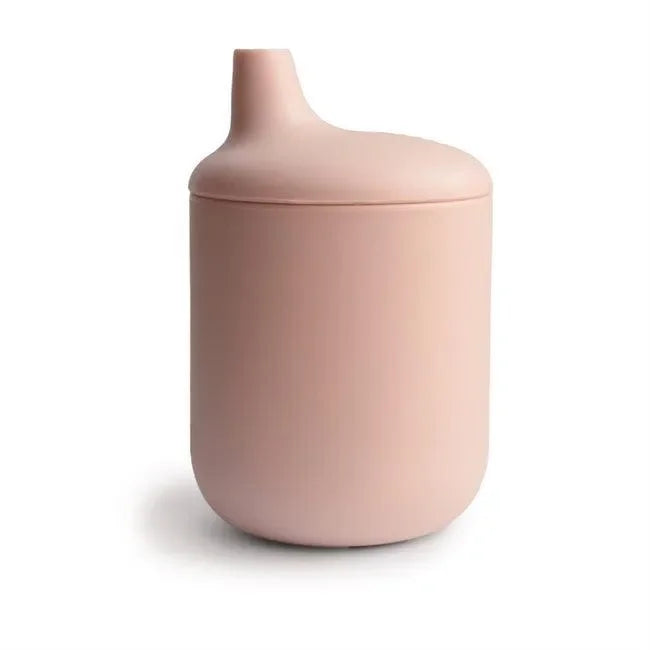 Rosa Silikon-Trinklernbecher für Babys auf weißem Hintergrund, minimalistisch und auslaufsicher.