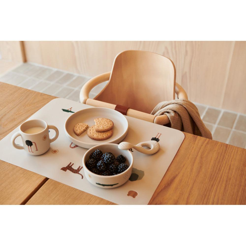 Kindergeschirr-Set mit Keksen, Brombeeren und Milch auf Tisch, Hochstuhl, skandinavisches Design
