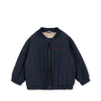 Navy blue quilted baby jacket with front zipper and red stitched text on chest against white background